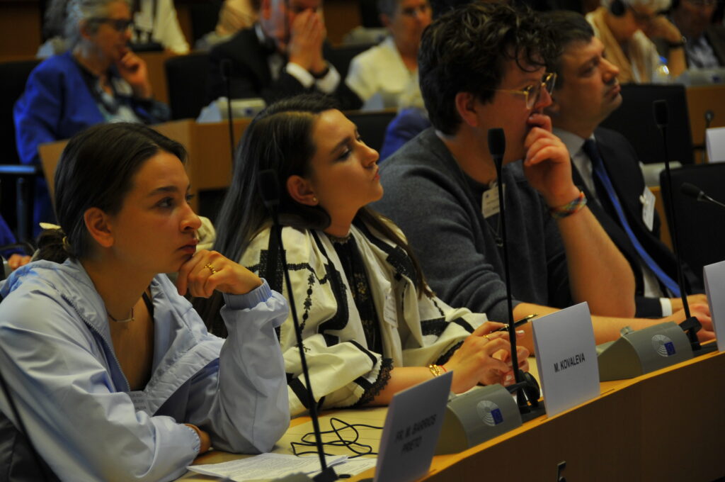 Persone sedute in conferenza ascoltando attentamente.