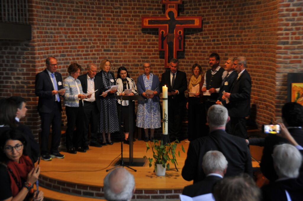 Persone cantano in chiesa durante una cerimonia religiosa.